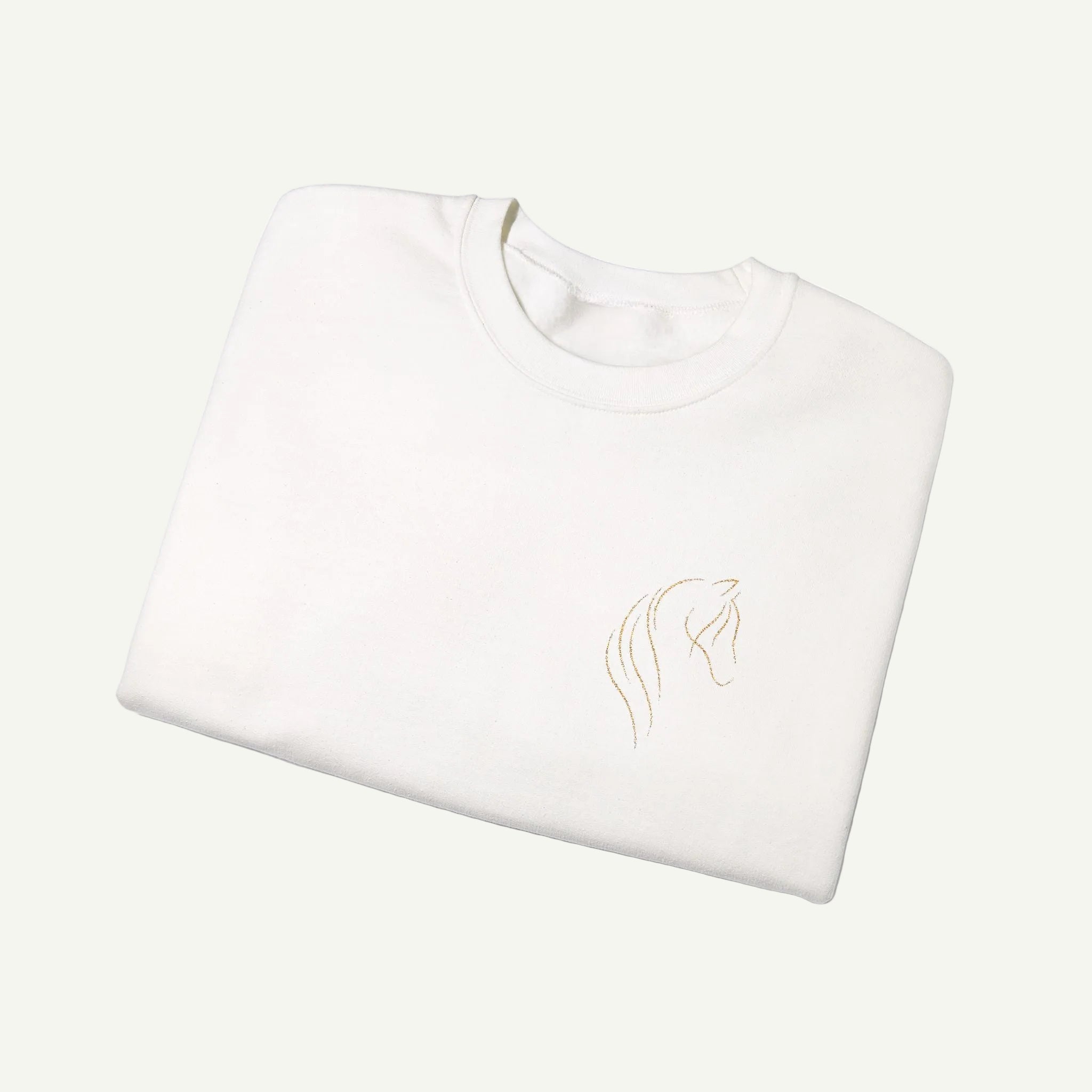 Folded white sweatshirt with a gold logo on a white background