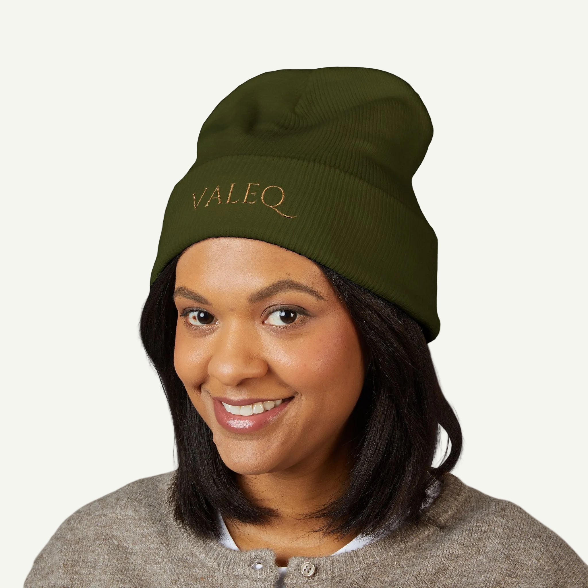 Person wearing a green beanie with 'VALEQ' embroidery on a white background