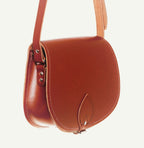 Brown leather saddle bag on a white background