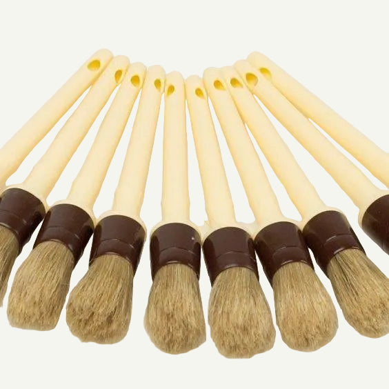 Set of small brushes with bristle heads and brown handles on a white background