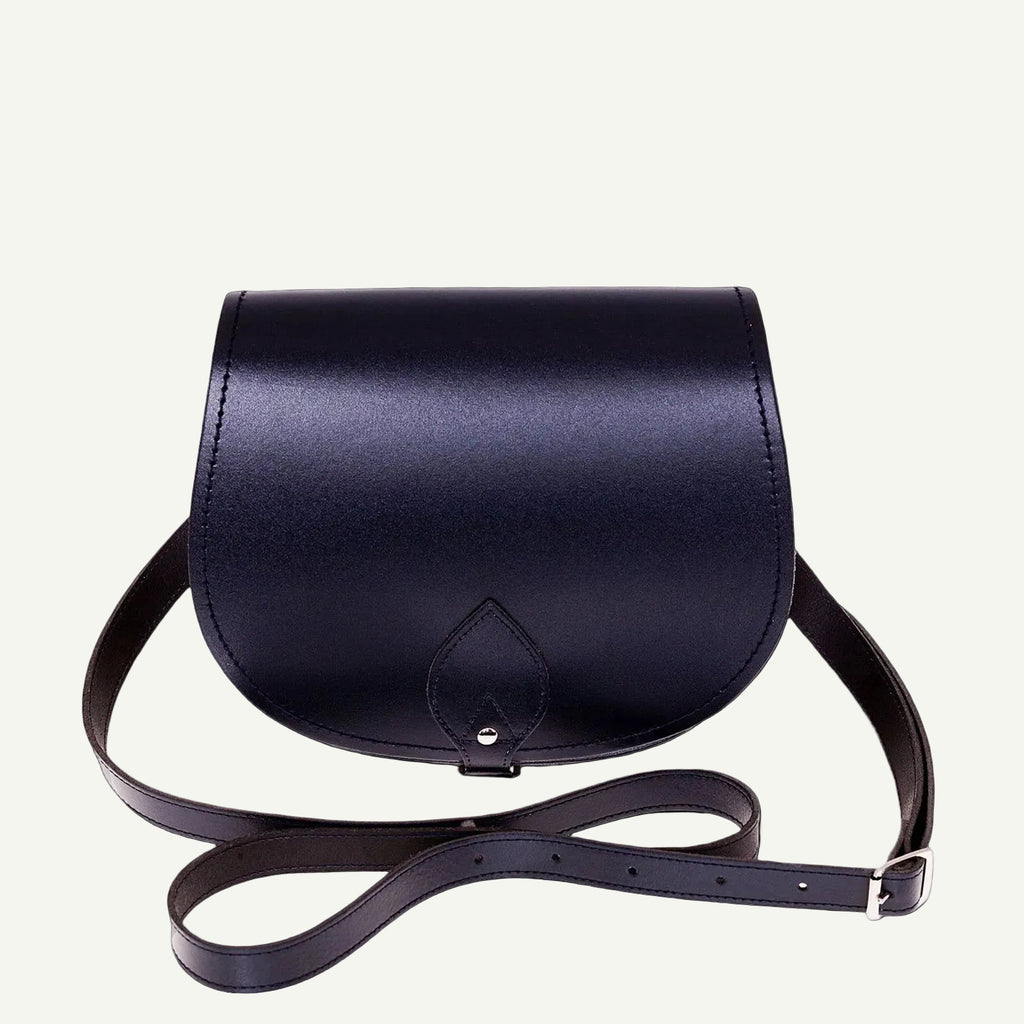 Navy leather saddle bag with a strap on a white background