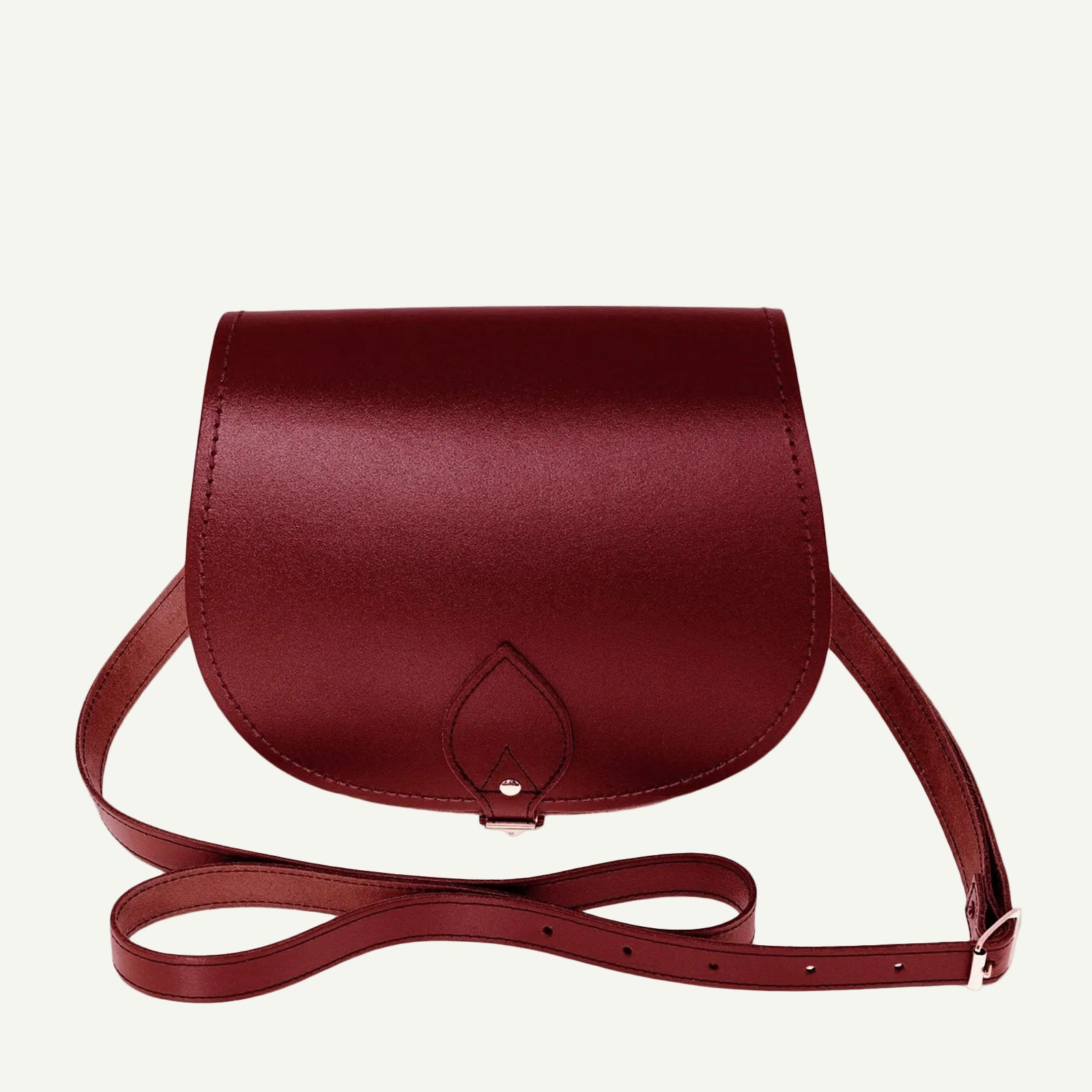 Red leather handbag with a strap on a white background